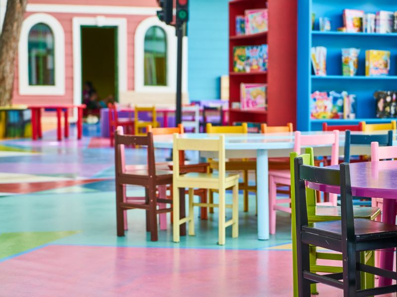 Na zdjęciu sala przedszkolna. Widać stoliki i krzesełka kolorowe